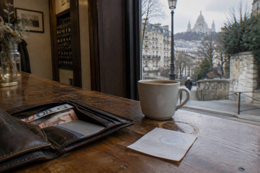 Wallet with euro banknotes and a debit card on a wooden hotel counter