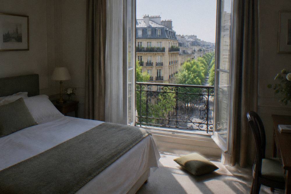 Paris hotel room with a double bed and a window onto a Haussmann street