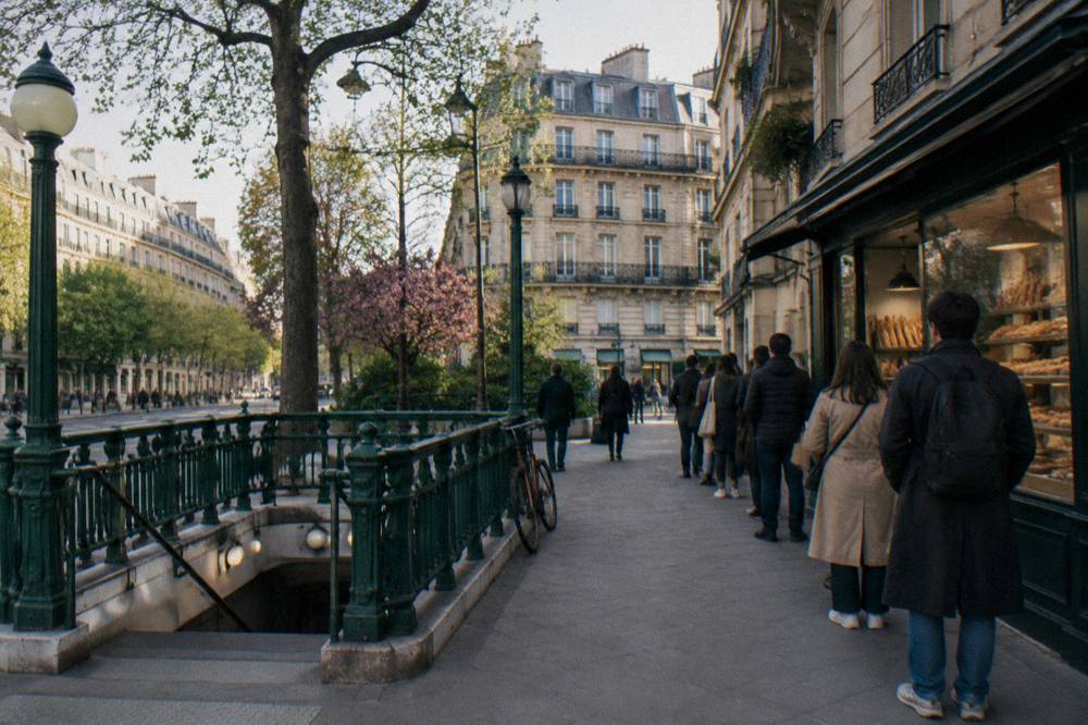 Residential Paris street with Haussmann-style apartment buildings and a metro entrance in the foreground