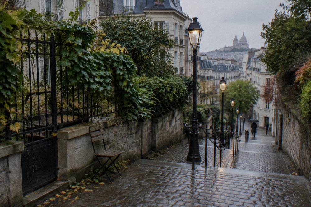 Cobbled lane climbing a hill with lampposts and ivy-covered walls