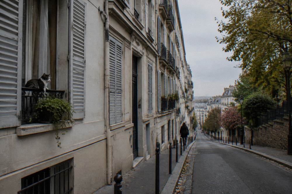 A narrow Paris street in the 18th arrondissement with apartment balconies and shuttered windows