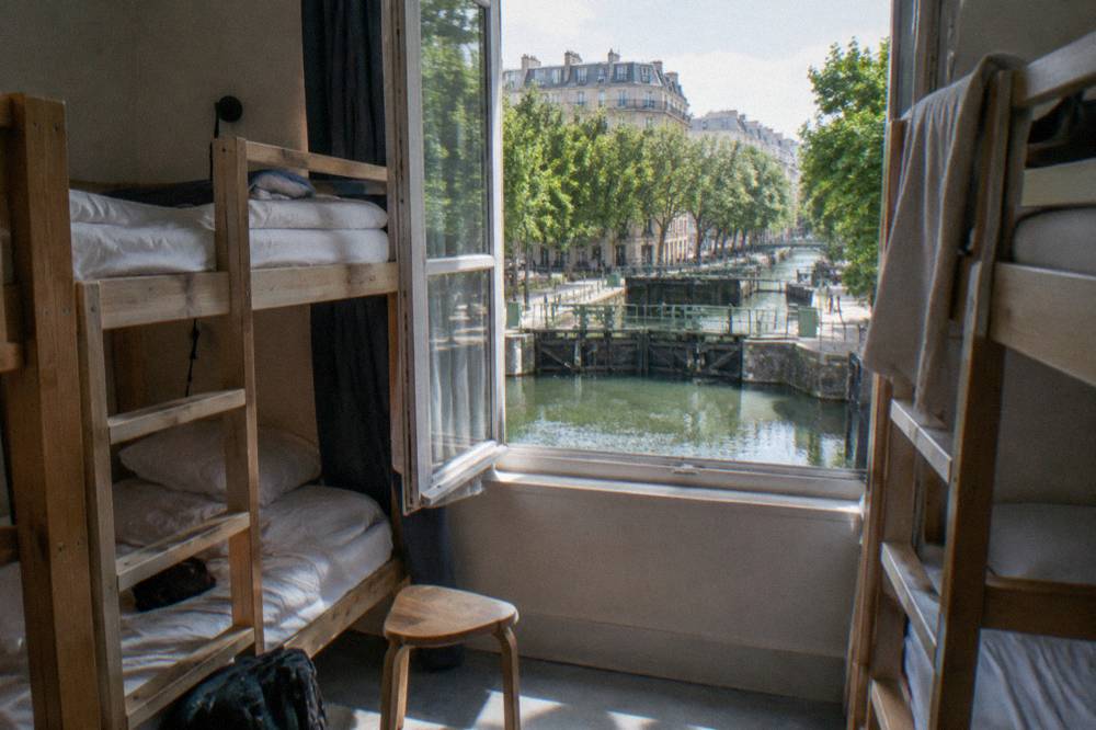 Bunk beds in a bright hostel dorm room with wooden frames