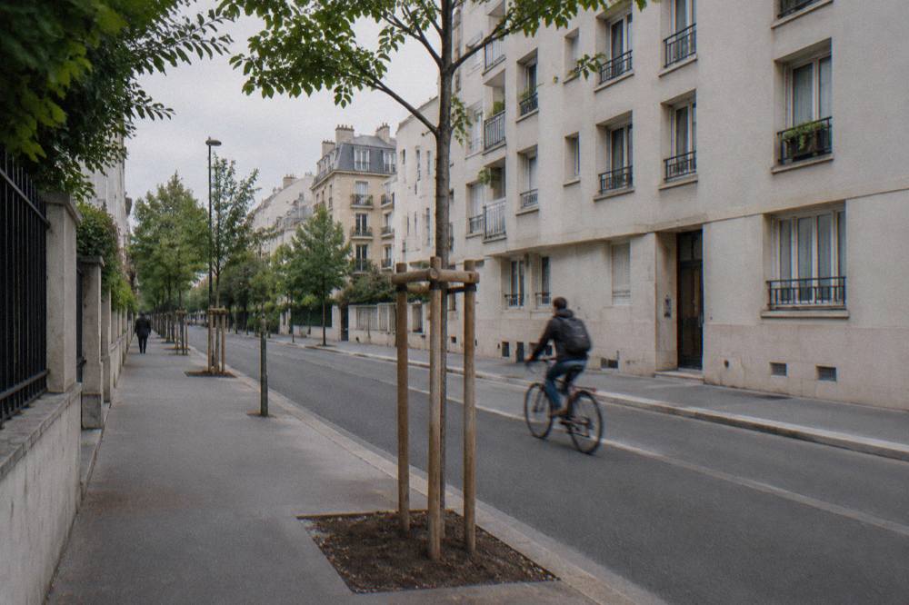 A quiet Paris street of mid-rise apartment buildings near a city edge district