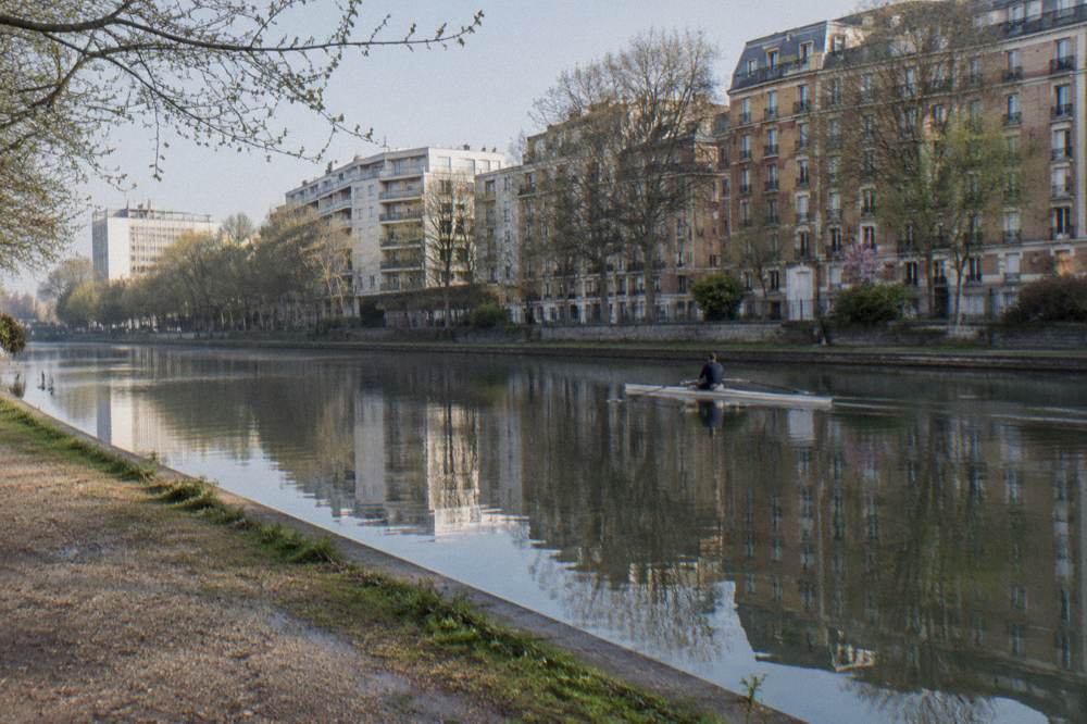 A Paris canal-side street in the nineteenth arrondissement with trees and apartment buildings