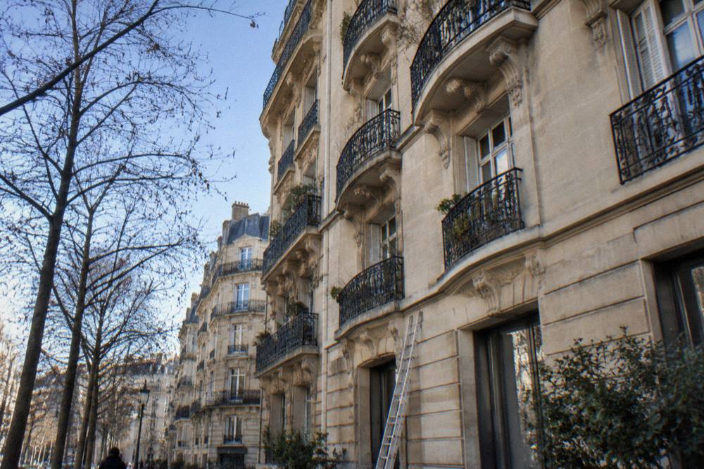 A classic Parisian facade with wrought-iron balconies on a quiet morning street
