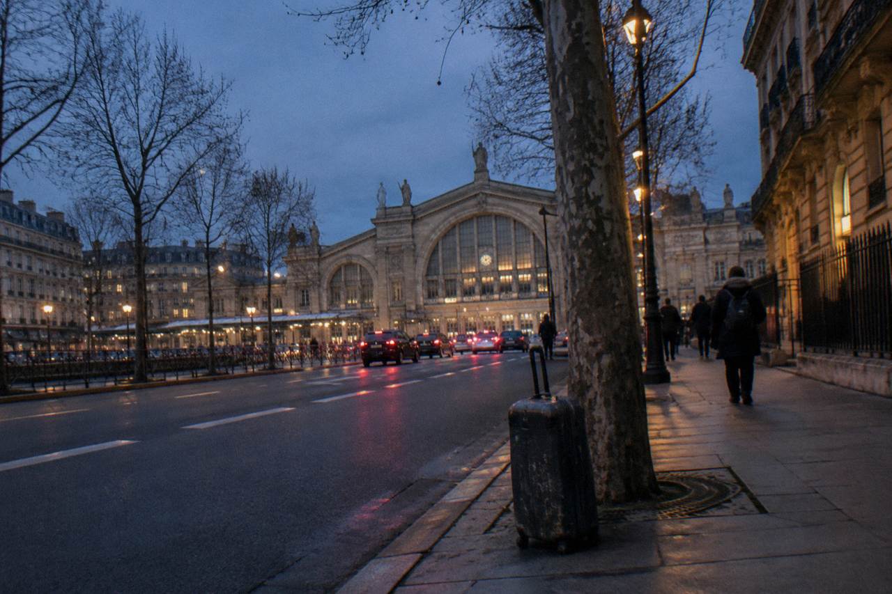 Evening view of a Paris boulevard with station architecture in the distance