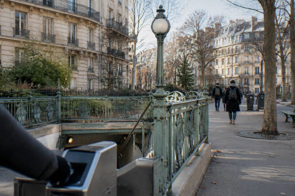 A metro station entrance sign on a Paris sidewalk beside apartment buildings