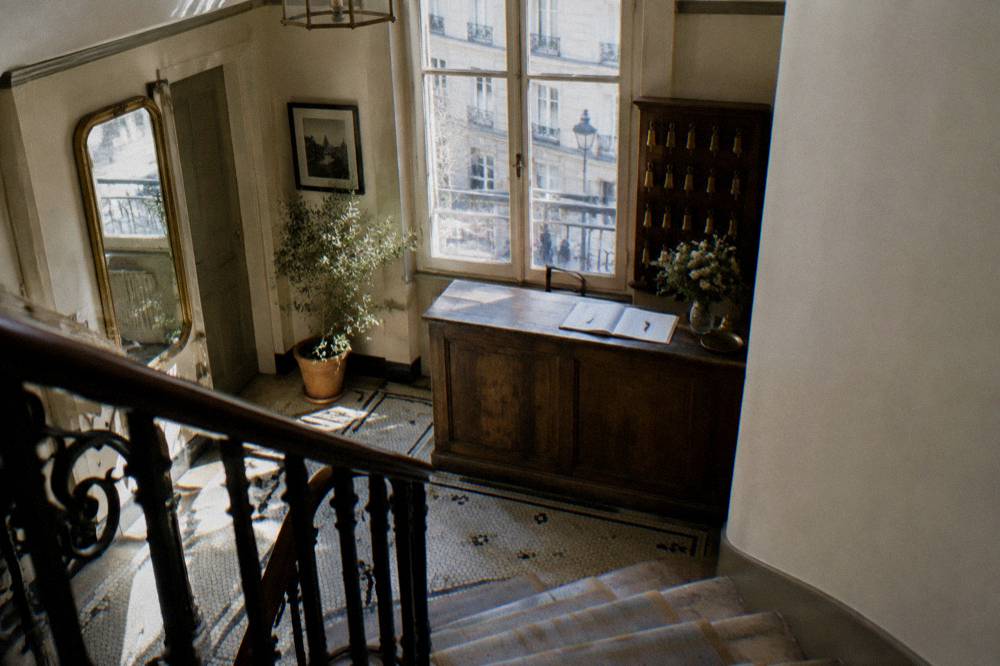 A reception desk in a small Paris hotel with a wooden counter and room keys