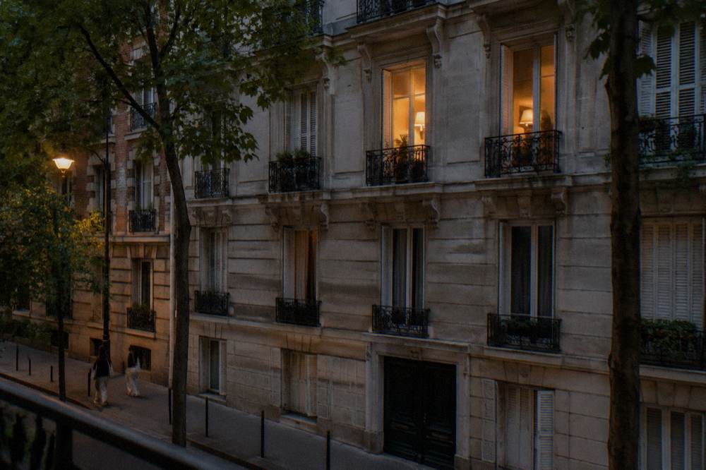 A row of traditional Parisian apartment buildings with wrought-iron balconies on a residential street