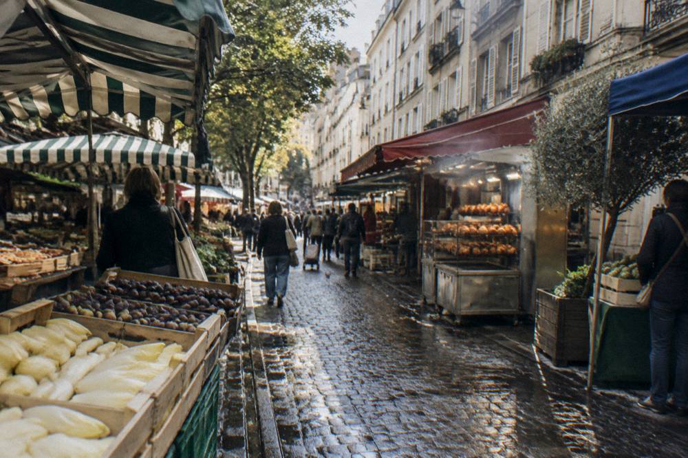 Narrow street market in a Paris neighbourhood with awnings and stalls