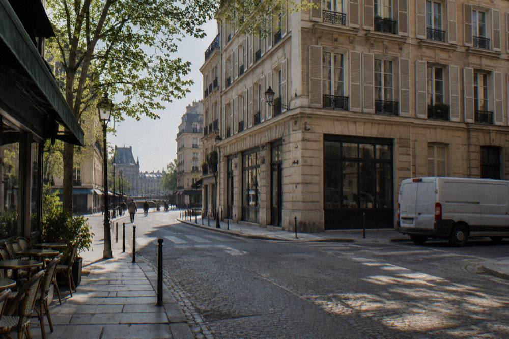 A quiet Paris street corner with cream-coloured facades and shuttered windows